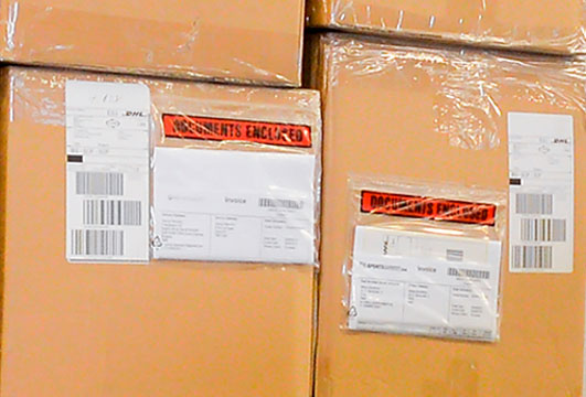 Paquetes con documentación de aduanas adherida en el exterior del paquete usando un portadocumentos transparente